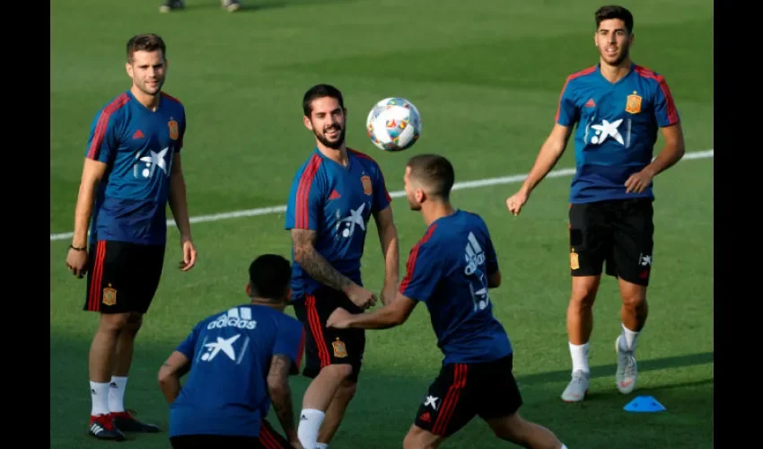 El defensa Nacho Fernández (i), y los centrocampista Isco (2i) y Marco Asensio (d) con sus compañeros durante el entrenamiento. Foto:EFE