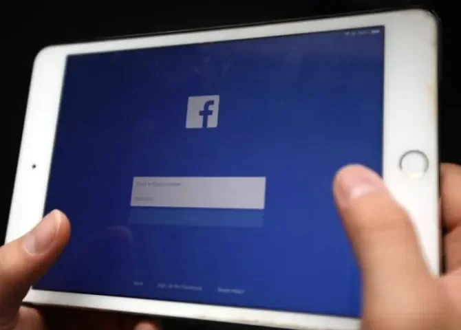   Una persona sostiene un dispositivo electrónico en la que aparece la página de inicio de la red social Facebook. EFE/ Luong Thai Linh  